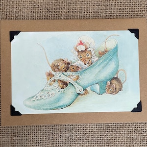 May include: A blue shoe with a lace design is filled with a group of mice. The mice are brown and gray and have small pink noses. The shoe is on a white background.