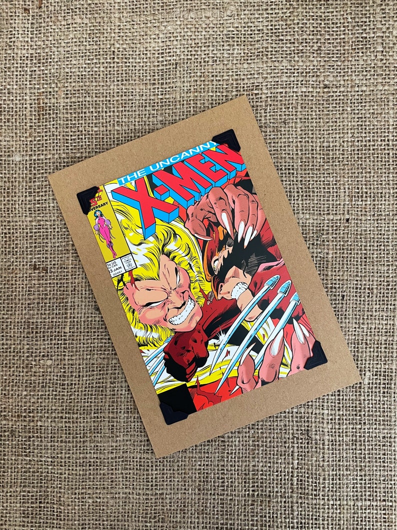 Puede incluir: Una portada de c&oacute;mic con Wolverine y Sabretooth en una pelea. La portada es roja, amarilla y azul con el t&iacute;tulo "The Uncanny X-Men" en letras grandes y en negrita.