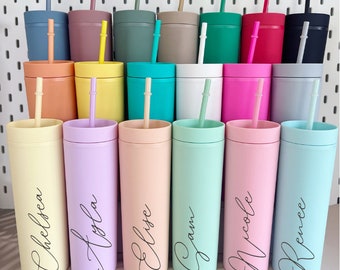 May include: A set of 10 personalized tumblers with various pastel colors and names written in cursive. The tumblers are arranged in two rows, with the names facing the viewer. The tumblers are all the same size and shape, and they have a straw.
