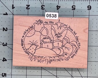 May include: Wooden stamp featuring a nativity scene with a donkey, sheep, and rabbit. The text reads "Lord Jesus laid down His sweet head. Away in a manger, no crib for a bed." The stamp has the number "0538" on it.