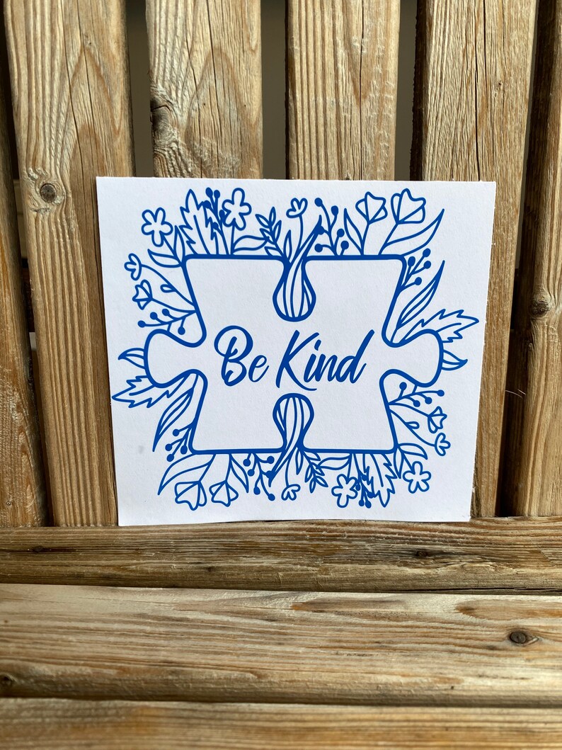 May include: Blue puzzle piece with the words "Be Kind" surrounded by a border of blue flowers and leaves on a white background.