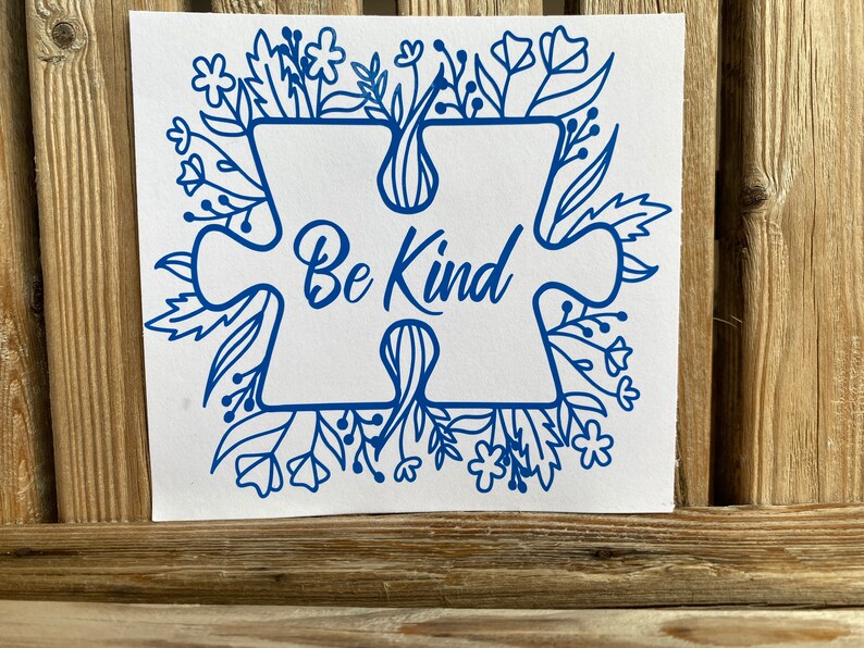 May include: Blue puzzle piece with the words "Be Kind" surrounded by a floral design.