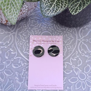 May include: A pair of green and black patterned fabric stud earrings on a pink card with the text "Murray Designs by Lisa Handcrafted in Adelaide Surgical steel posts and backs www.etsy.com/au/shop/MurrayDesignsbyLisa"