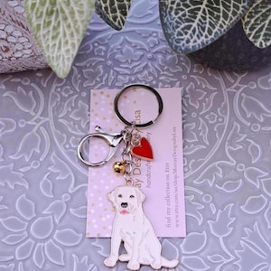 May include: A silver keyring with a red heart charm, a small bell charm, and a white Labrador Retriever charm. The keyring is attached to a card that says "Murray Designs by Lisa" and "find my collection on Etsy www.etsy.com/au/shop/MurrayDesignsbyLisa".