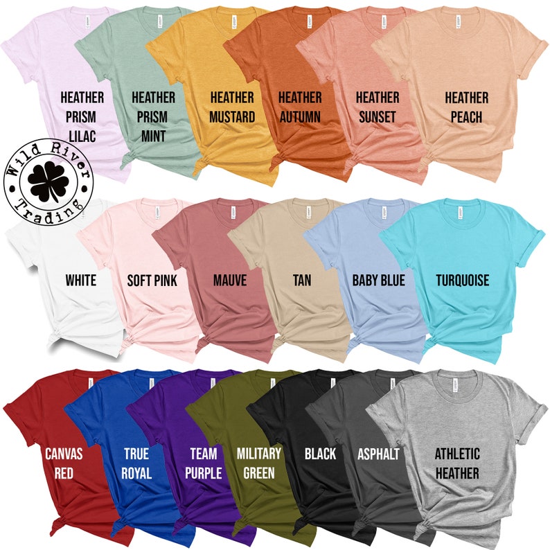 Op de afbeelding: Een selectie van 20 verschillende gekleurde T-shirts met verschillende tekst bedrukt op de voorkant. De tekst bevat kleurennamen zoals "Heather Prism Lilac", "Heather Prism Mint", "Heather Mustard", "Heather Autumn", "Heather Sunset", "Heather Peach", "White", "Soft Pink", "Mauve", "Tan", "Baby Blue", "Turquoise", "Canvas Red", "True Royal", "Team Purple", "Military Green", "Black", "Asphalt", and "Athletic Heather".