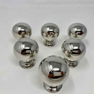 May include: Six polished chrome cabinet knobs with a round ball shape and a small base.