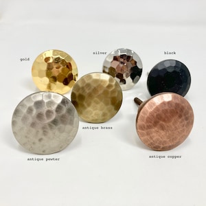 May include: Assortment of hammered metal cabinet knobs in various finishes, including gold, silver, antique brass, antique copper, and black.
