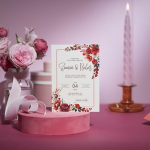 Peut inclure: Une invitation de mariage avec un motif floral compos&eacute; de coquelicots rouges et de feuilles vertes. L'invitation est imprim&eacute;e sur du papier cartonn&eacute; blanc et poss&egrave;de une bordure dor&eacute;e. Le texte de l'invitation indique "Ensemble avec leurs familles, Samira & Rubus, vous invitent &agrave; c&eacute;l&eacute;brer leur mariage le dimanche 4 juin 2023 &agrave; 16h00."