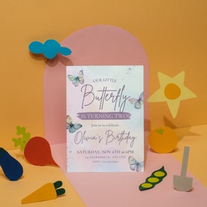 May include: A purple and white invitation with a watercolor background and butterflies. The text reads "Our Little Butterfly is Turning Two!" and "Join us to celebrate Olivia's Birthday, Saturday, Nov 6th at 6PM, Anywhere St., Any City."