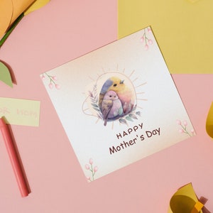 May include: A white card with a watercolour illustration of two birds in a nest. The card says "Happy Mother's Day".