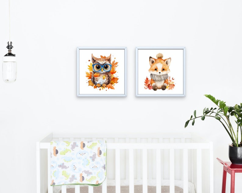 May include: Two framed watercolor paintings of woodland animals. The first painting features an owl wearing blue glasses and surrounded by orange and yellow leaves. The second painting features a fox wearing a gray scarf and surrounded by orange and yellow leaves.