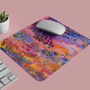 May include: A colourful abstract mouse mat with a swirling pattern of purple, orange, yellow, and blue. The mouse mat has a white computer mouse on top of it.