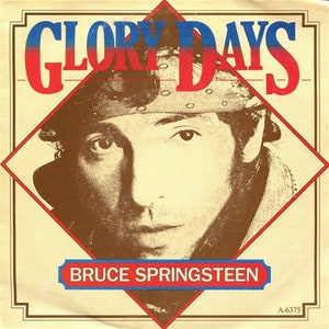 May include: A vintage record sleeve featuring a close-up portrait of Bruce Springsteen. The sleeve is red, white and blue with the title "Glory Days" in large, bold letters. The record number "A-6375" is printed in the bottom right corner.