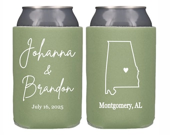 May include: Two green and white personalized can coolers. One cooler has the text "Johanna & Brandon July 16, 2025". The other cooler has an outline of the state of Alabama with a heart in the center and the text "Montgomery, AL".