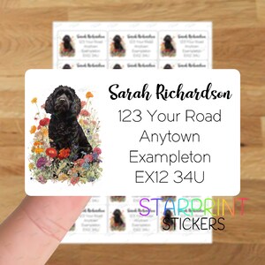 May include: A white rectangular return address label with black text. The label features a black and white illustration of a dog in a field of flowers. The text reads "Sarah Richardson, 123 Your Road, Anytown Exampleton, EX12 34U".