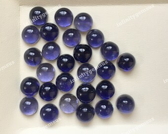 May include: A collection of 20 round, smooth, purple and blue gemstone cabochons. The cabochons are approximately 10mm in diameter and have a polished, glossy finish.