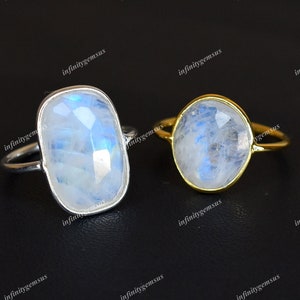 May include: Two rings featuring moonstone gemstones. The ring on the left has a silver band and a rectangular moonstone. The ring on the right has a gold band and a round moonstone.