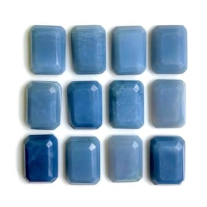 Peut inclure: Douze cabochons de pierres précieuses bleues, chacun taillé en forme rectangulaire avec des bords biseautés. Les pierres sont disposées en grille.
