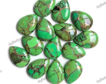 May include: A collection of 13 green turquoise cabochons with copper inclusions. The cabochons are pear-shaped and have a smooth, polished finish.