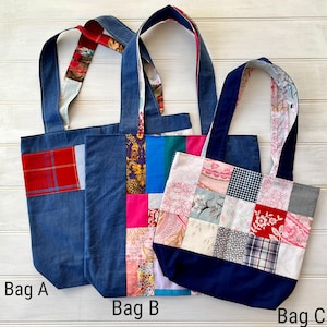 May include: Three tote bags made from denim fabric with patchwork designs. Bag A has a red and white plaid design. Bag B has a colourful patchwork design with pink, blue, and green fabrics. Bag C has a patchwork design with pink, white, and grey fabrics.