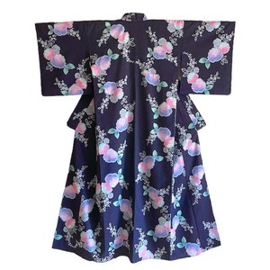 Puede incluir: Un kimono azul oscuro con un patrón floral con flores rosas, blancas y azules. El kimono tiene mangas largas y una silueta ancha y fluida.