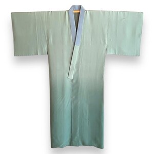 Puede incluir: Un kimono de seda verde claro con cuello azul y una faja azul contrastante.