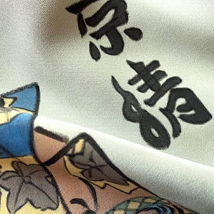 Puede incluir: Una tela azul claro con caracteres japoneses negros que se leen "深海" (mar profundo) y una ilustraci&oacute;n colorida de un pez con un dise&ntilde;o floral.