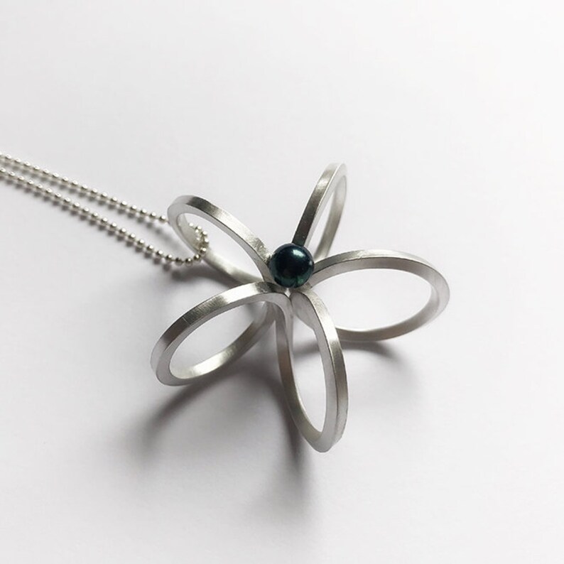 Long silver necklace with a special flower pendantscandinaviangraphic