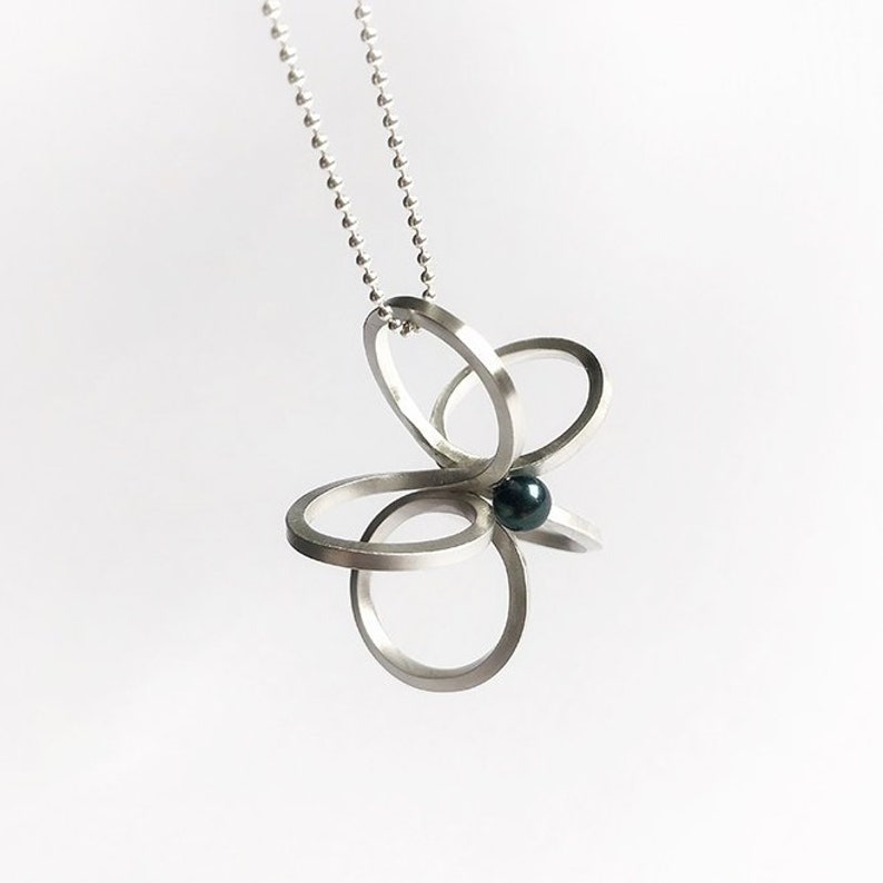 Long silver necklace with a special flower pendantscandinaviangraphic