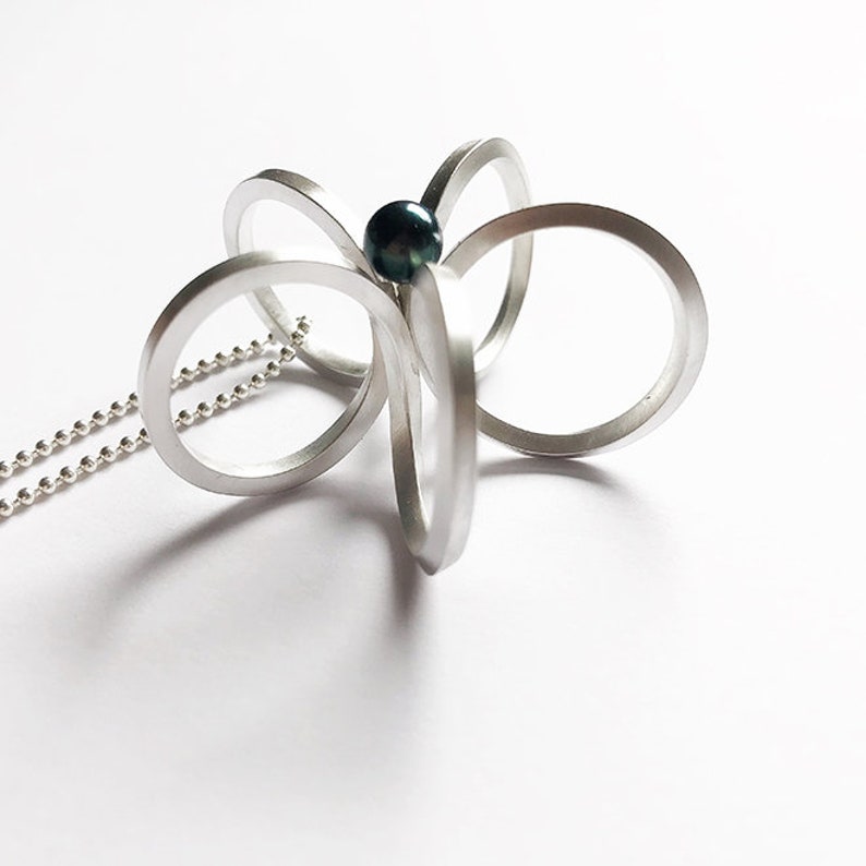 Long silver necklace with a special flower pendantscandinaviangraphic