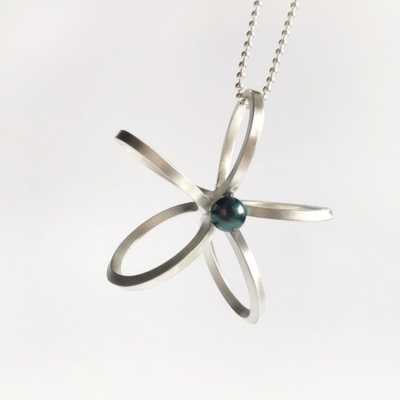 Long silver necklace with a special flower pendantscandinaviangraphic