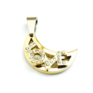 May include: Gold-tone pendant in a crescent moon shape, featuring the word "LOVE" spelled out with clear crystals. The pendant has a silver-colored bail for attaching to a chain. The jewelry is set against a white background.