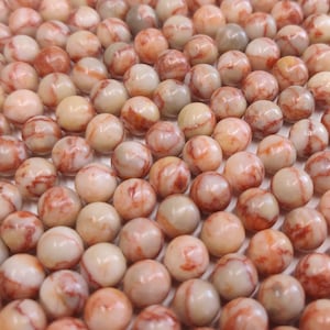 May include: A strand of round, white and red marbled beads. The beads have a natural, organic look and are perfect for jewellery making.