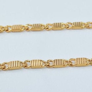 Puede incluir: Un collar de cadena de oro con un patr&oacute;n de eslabones rectangulares.