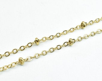 May include: Close-up of two delicate gold-colored necklaces. Each necklace features a fine chain with evenly spaced, small, round beads. The chains are displayed against a plain white background, highlighting the jewelry's details.