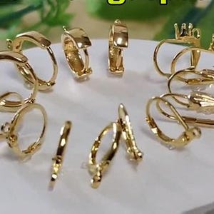 May include: A collection of gold-toned earring findings, including hoops, leverbacks, and clip-on styles. These findings are perfect for creating custom earrings.
