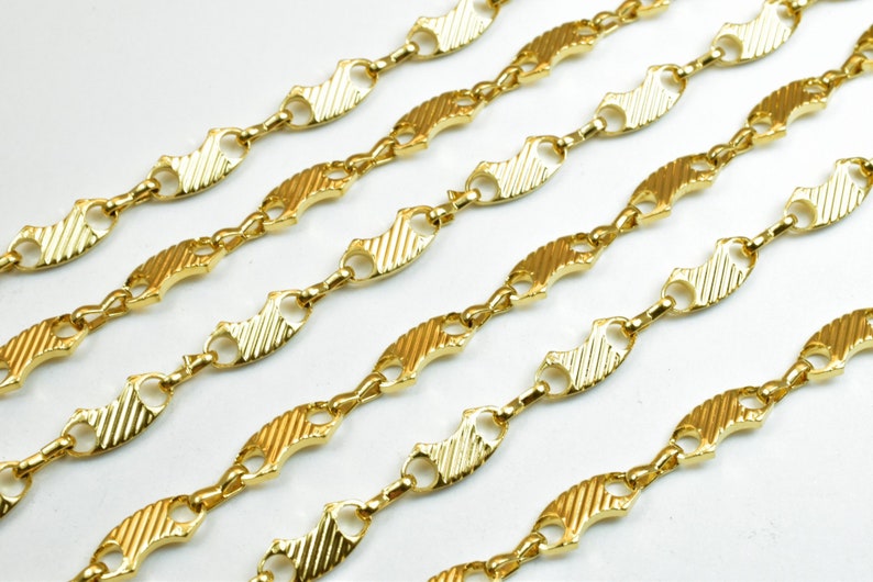 Op de afbeelding: Gouden ketting met een textuur, visvormig schakeld ontwerp.