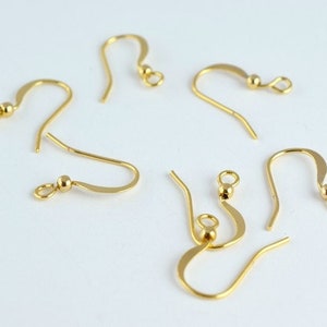 May include: Six gold-toned earring hooks with a small ball at the top of each hook.