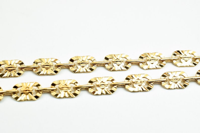 May include: A gold chain necklace with a patterned link design.