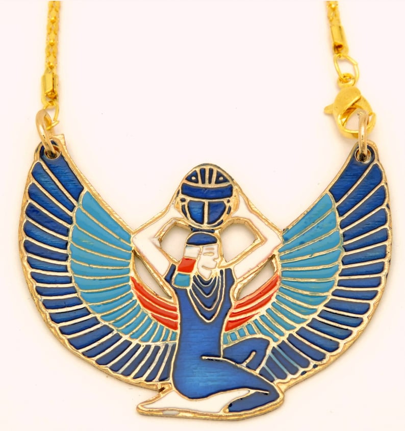May include: Gold necklace with a blue and white enamel pendant depicting the Egyptian goddess Isis with outstretched wings. The pendant features a red and white design on the goddess's body and a blue sphere held above her head.