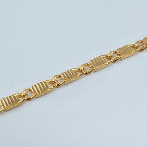 Puede incluir: Un collar de cadena de oro con un dise&ntilde;o de eslab&oacute;n rectangular texturizado.