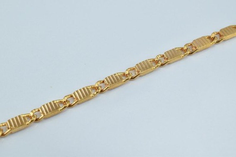 Puede incluir: Un collar de cadena de oro con un dise&ntilde;o de eslab&oacute;n rectangular texturizado.