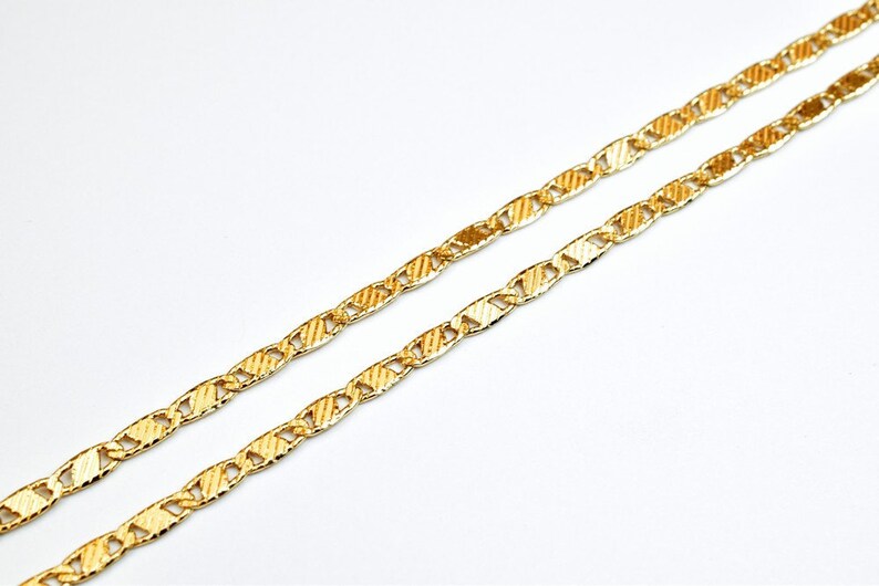 May include: A gold chain necklace with a textured, mariner link design.