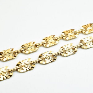 May include: A gold chain necklace with a textured, oval-shaped link design.