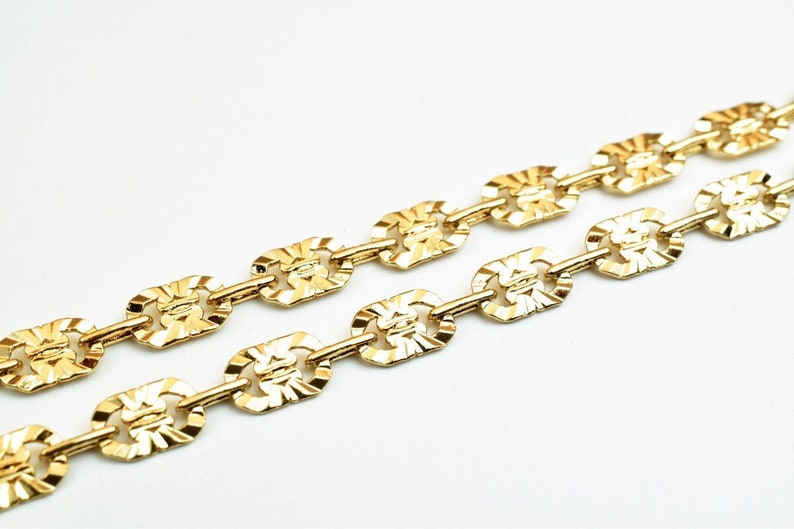 May include: A gold chain necklace with a textured, oval-shaped link design.