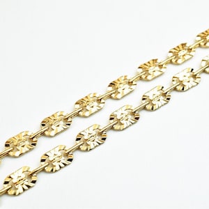 May include: A gold chain necklace with a textured, oval-shaped link design.