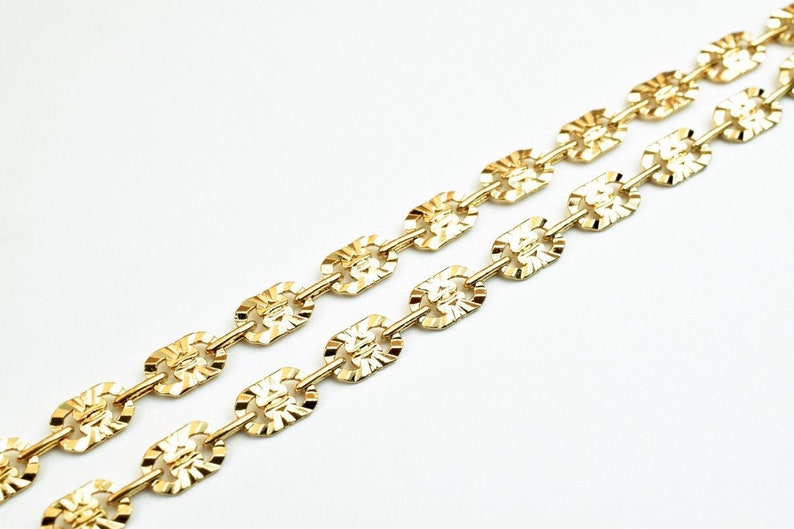 May include: A gold chain necklace with a textured, oval-shaped link design.