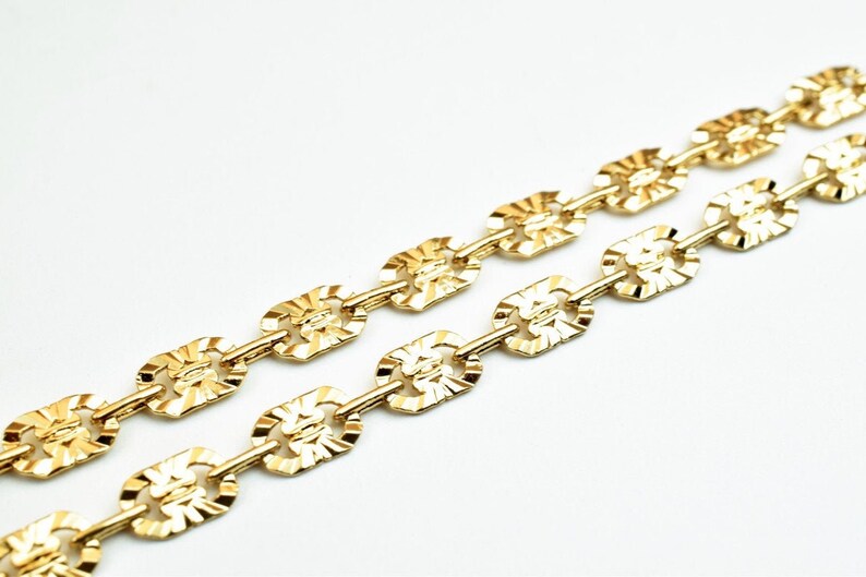 May include: A gold chain necklace with a textured, oval-shaped link design.