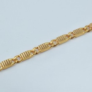 Puede incluir: Un collar de cadena de oro con un dise&ntilde;o de eslab&oacute;n rectangular texturizado.
