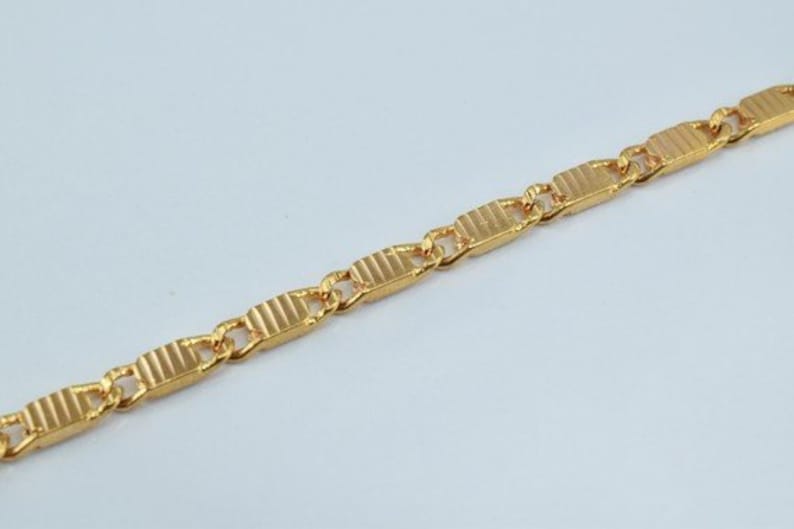 Puede incluir: Un collar de cadena de oro con un dise&ntilde;o de eslab&oacute;n rectangular texturizado.